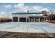 Gray metal barn-style home with triple garage doors and covered porch at 219 Mock Mill Rd, Statesville, NC 28677