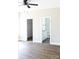 Bright bedroom featuring wood floors, ceiling fan, and doorways to a bathroom and closet at 2220 Badin Rd, Albemarle, NC 28001