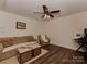 A well-lit living room with comfortable seating, a ceiling fan, and hardwood floors at 3020 Graceland Cir # 11D, Pineville, NC 28134