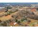 Aerial view showing home on large lot with mature trees and nearby buildings at 3510 Oakwood Ave, Claremont, NC 28610