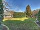 Spacious backyard featuring a well-manicured lawn, mature trees, and privacy hedges at 3827 Bramwyck Dr, Charlotte, NC 28210