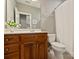Neutral bathroom with a wood vanity, a toilet, and light tile floors at 3827 Bramwyck Dr, Charlotte, NC 28210