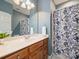 Well-lit bathroom with a wood vanity, a large mirror, and floral accents at 3827 Bramwyck Dr, Charlotte, NC 28210