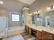 Spacious main bathroom with a soaking tub, double vanities, and neutral color palette at 3827 Bramwyck Dr, Charlotte, NC 28210