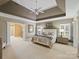 Main bedroom with a tray ceiling, carpeted floors, and natural light at 3827 Bramwyck Dr, Charlotte, NC 28210