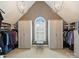 Bright walk-in closet featuring custom shelving, storage cabinets, and a window seat at 3827 Bramwyck Dr, Charlotte, NC 28210