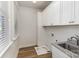 Bright laundry room with white cabinets, granite countertops, and wood-look flooring at 630 Daventry Ct, Clover, SC 29710