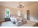 Spacious primary bedroom with a king-size bed, plush seating, and a chandelier at 720 Ideal Way, Charlotte, NC 28209