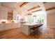 Modern kitchen with white cabinets, a light green island, and hardwood floors at 720 Ideal Way, Charlotte, NC 28209