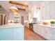 Bright kitchen featuring a teal island, white cabinets, and exposed wooden beams at 720 Ideal Way, Charlotte, NC 28209