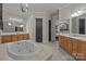 Open bathroom featuring dual vanities, corner jacuzzi tub, decorative fixtures, and access to the bedroom at 7409 Stonecroft Park Dr, Charlotte, NC 28226