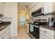 Nicely appointed kitchen with stone tile backsplash, stainless steel appliances, and tile floors at 1077 Sardis Cove Dr, Charlotte, NC 28270