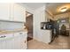 Open concept kitchen with white cabinets, stainless appliances and view to the living room at 1077 Sardis Cove Dr, Charlotte, NC 28270