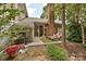 Private patio featuring lounge chairs, lush greenery, and an eye-catching brick fireplace at 1077 Sardis Cove Dr, Charlotte, NC 28270