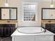 Bright bathroom features double vanities, soaking tub and a window for natural light at 11052 Preservation Park Dr, Charlotte, NC 28214