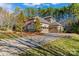 Spacious home with a long driveway and a three-car garage, surrounded by lush trees at 11052 Preservation Park Dr, Charlotte, NC 28214