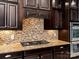 Gas cooktop with granite countertops and dark wood cabinets at 11052 Preservation Park Dr, Charlotte, NC 28214