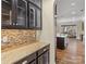 Butlers pantry with granite countertops and glass-front cabinets at 11052 Preservation Park Dr, Charlotte, NC 28214