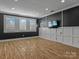 Large living room with dark colored walls, beautiful hardwood floors, and multiple windows at 11052 Preservation Park Dr, Charlotte, NC 28214