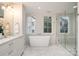Bright bathroom featuring marble floors, double sink vanity, soaking tub, and walk-in shower at 2400 Mecklenburg Ave, Charlotte, NC 28205