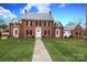 Charming brick home featuring a manicured lawn, stone walkway, and classic architectural details at 2400 Mecklenburg Ave, Charlotte, NC 28205