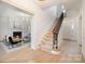 Elegant foyer featuring a staircase, light hardwood floors, and a view into the inviting living room at 2400 Mecklenburg Ave, Charlotte, NC 28205