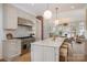 Modern kitchen with stainless steel appliances, large island, pendant lighting and view to the living room at 2400 Mecklenburg Ave, Charlotte, NC 28205