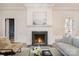 Cozy living room with a fireplace, marble surround, hardwood floors, and ample natural light at 2400 Mecklenburg Ave, Charlotte, NC 28205
