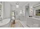 Large bathroom with double vanity, soaking tub, and marble details at 413 Eastover Rd, Charlotte, NC 28207