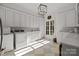 Bright laundry room with white cabinets, window, and washer/dryer at 413 Eastover Rd, Charlotte, NC 28207