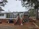 Back exterior showing sunroom, patio, and landscaping at 4718 Americana Ave, Charlotte, NC 28215