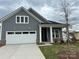 Charming new construction with vertical siding, white trim, covered entry, and an attached two car garage at 5213 Mint Harbor Way # 0351, Charlotte, NC 28269