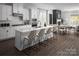 Open concept kitchen with white cabinets, large island, and hardwood floors at 5213 Mint Harbor Way # 0351, Charlotte, NC 28269