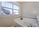 Bright bathroom featuring a soaking tub with decorative tile and a window offering natural light at 724 Mercer Pl, Huntersville, NC 28078