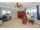Spacious bedroom with a ceiling fan, large windows, desk, and a comfortable leather chair with bookshelf at 724 Mercer Pl, Huntersville, NC 28078