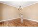 Cozy bedroom featuring hardwood floors, neutral paint, chandelier and unique arched doorway at 7545 Haley Ln, Indian Land, SC 29707