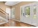 Bright foyer featuring decorative glass front door, hardwood floors, and staircase to the upper level at 7545 Haley Ln, Indian Land, SC 29707