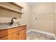 Functional laundry room with sink, granite countertop, and built-in shelving for storage solutions at 7545 Haley Ln, Indian Land, SC 29707