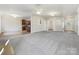 Open living room with grey carpet and views to kitchen at 9153 Leah Meadow Ln, Charlotte, NC 28227