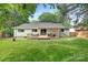 Backyard view of home featuring a wood deck with pergola and spacious lawn, perfect for outdoor entertaining at 10912 Treebark Dr, Charlotte, NC 28226