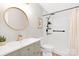 Modern bathroom features a round mirror, floating vanity, and walk-in shower with matte black hardware at 10912 Treebark Dr, Charlotte, NC 28226