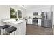 Bright kitchen features white cabinetry, stainless steel appliances, granite countertops and a large window overlooking the backyard at 10912 Treebark Dr, Charlotte, NC 28226
