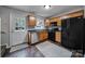 Kitchen with wood cabinets, black appliances, and tile floor at 1208 Piedmont St, Charlotte, NC 28204