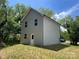 Angle view of house with light gray siding, green lawn, and surrounded by trees at 129 Sharon Rd, York, SC 29745