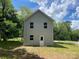 Back exterior view of two-story house featuring light gray siding and a small yard at 129 Sharon Rd, York, SC 29745