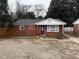 Brick ranch house with a gravel driveway and a wooden fence at 1401 Lasalle St, Charlotte, NC 28216