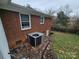 Brick house exterior showcasing a side view with AC unit and access to basement at 1401 Lasalle St, Charlotte, NC 28216