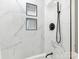 Clean bathroom with marble shower, black accents, and built-in shelves at 1408 Edgewater Dr, Charlotte, NC 28210