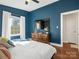 Spacious bedroom with blue walls, wood floors, and a dresser at 1408 Edgewater Dr, Charlotte, NC 28210