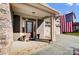 Inviting front porch with stone flooring, entry door, and American flag at 14818 Long Iron Dr, Huntersville, NC 28078